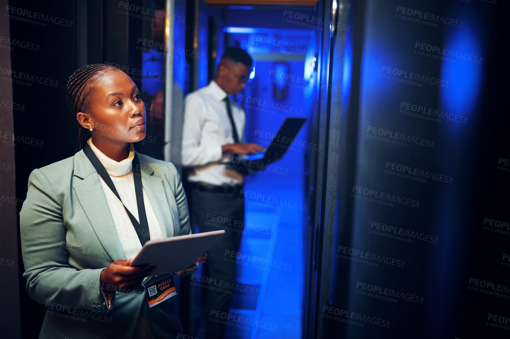 Buy stock photo Shot of a young woman using a digital tablet while working in a server room