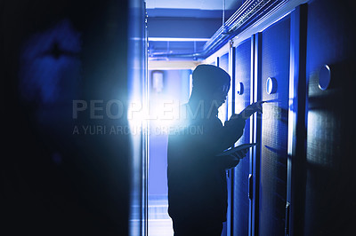 Buy stock photo Shot of a hacker using a digital tablet in a server room