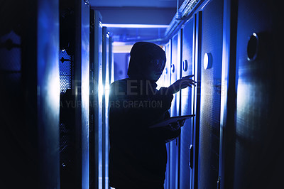 Buy stock photo Shot of a hacker using a digital tablet in a server room