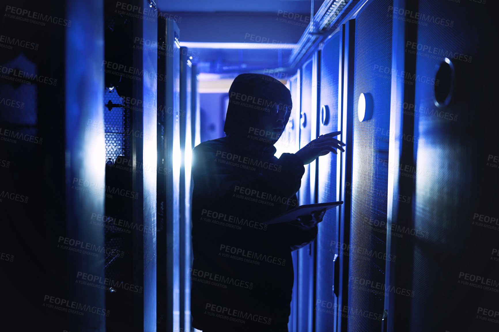 Buy stock photo Shot of a hacker using a digital tablet in a server room