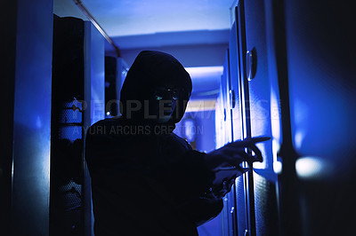 Buy stock photo Shot of a hacker using a digital tablet in a server room