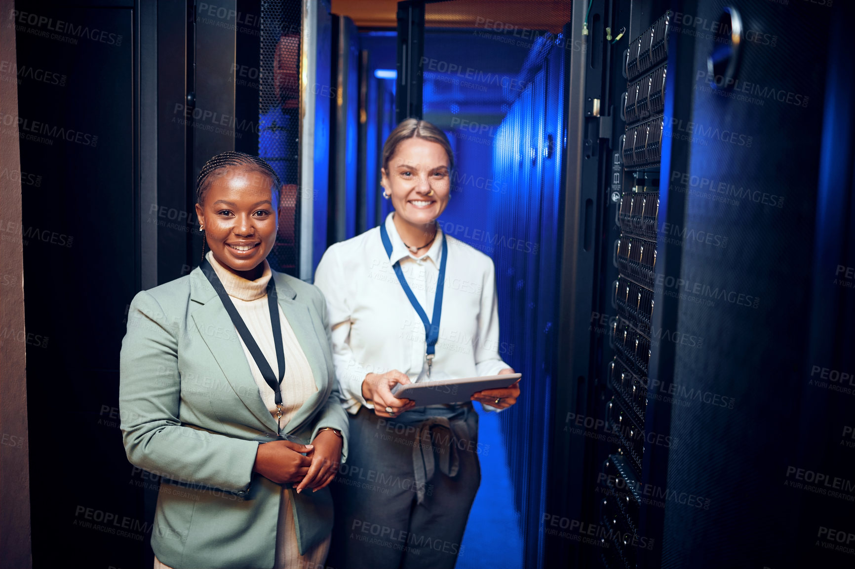 Buy stock photo Portrait of two technicians using a digital tablet while working in a server room