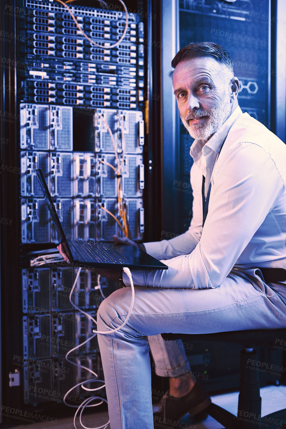 Buy stock photo Portrait of a mature man using a laptop while working in a server room