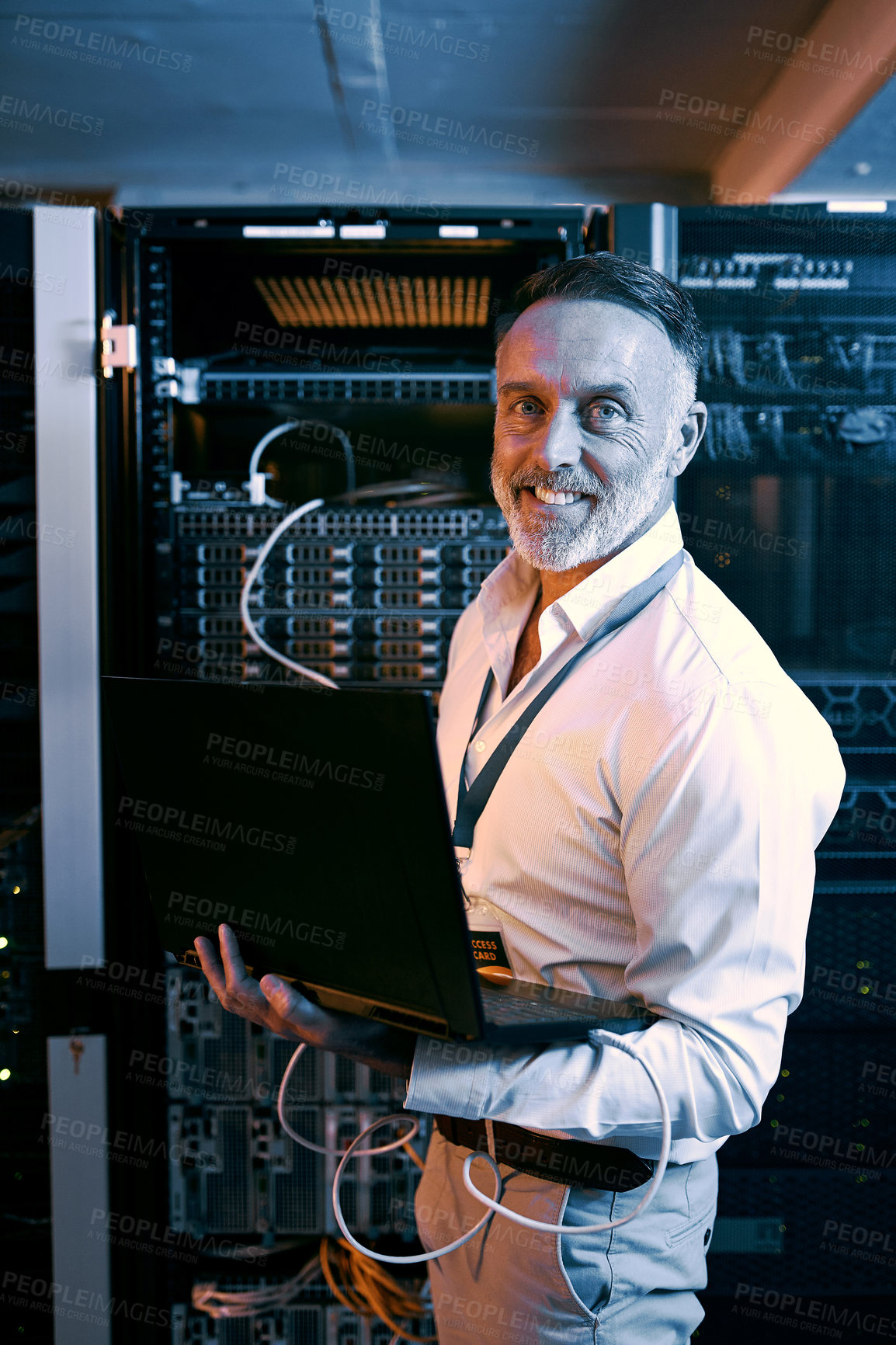 Buy stock photo Portrait of a mature man using a laptop while working in a server room