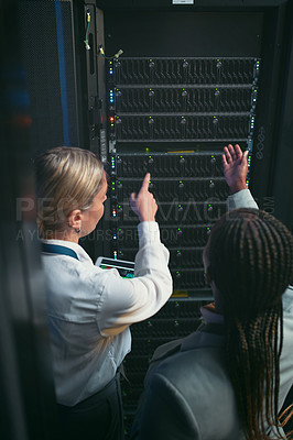 Buy stock photo Shot of two unrecognizable IT specialists standing in the server room and having a discussion