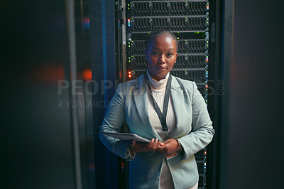 Buy stock photo Shot of a young IT specialist standing alone in the server room and using a digital tablet