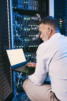 Buy stock photo Rearview shot of a mature man using a laptop while working in a server room