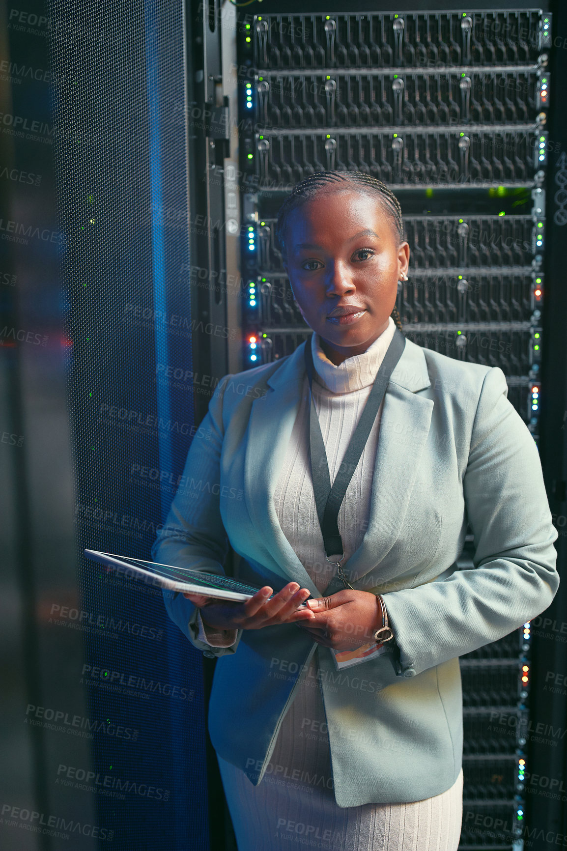 Buy stock photo Shot of a young IT specialist standing alone in the server room and using a digital tablet