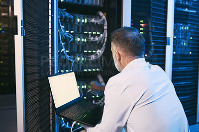 Buy stock photo Rearview shot of a mature man using a laptop while working in a server room