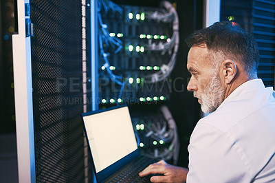 Buy stock photo Rearview shot of a mature man using a laptop while working in a server room