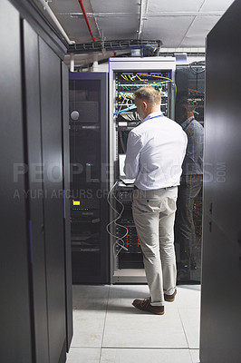 Buy stock photo Rearview shot of a mature man using a laptop while working in a server room