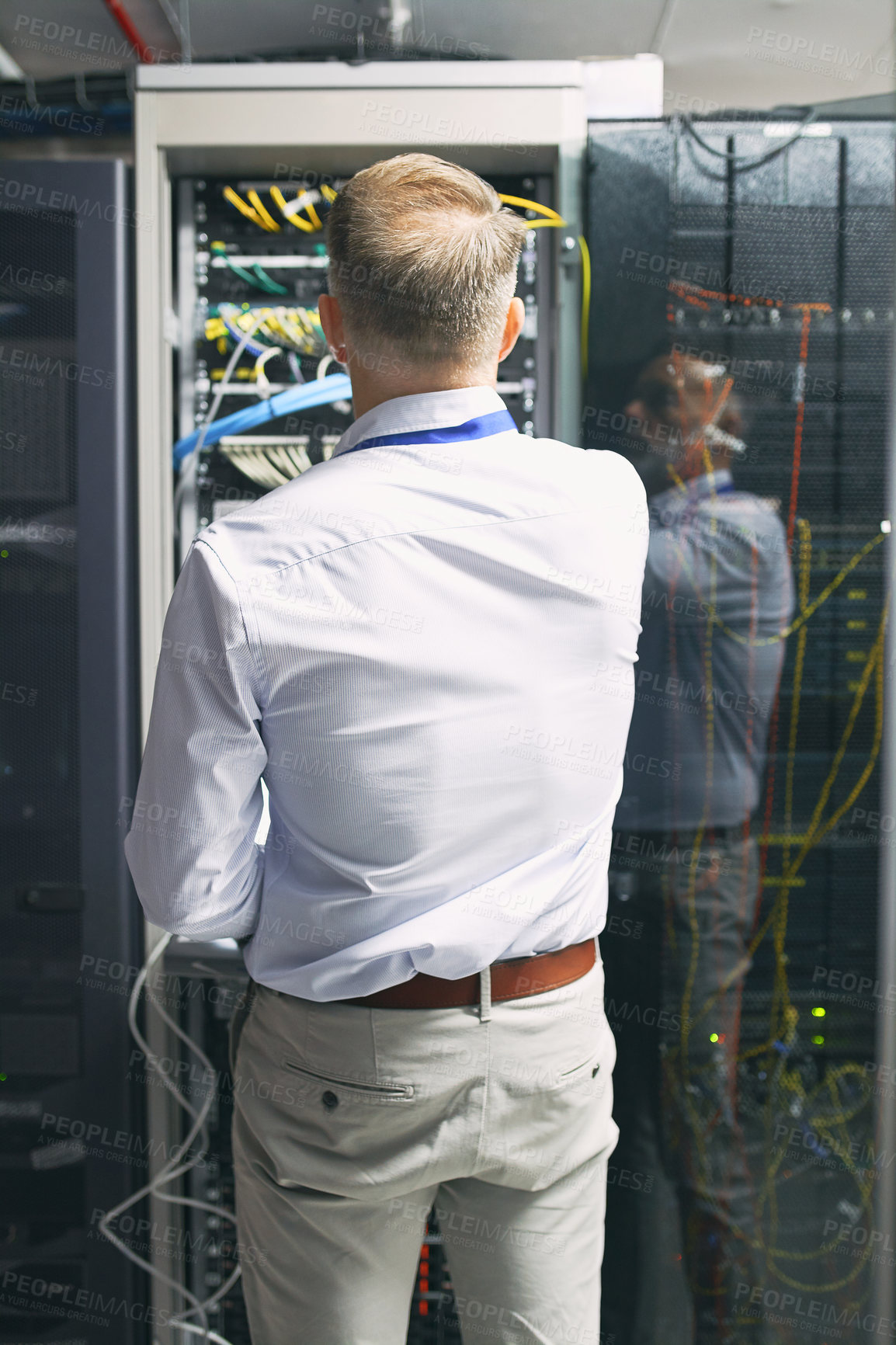 Buy stock photo Rearview shot of a mature man working in a server room