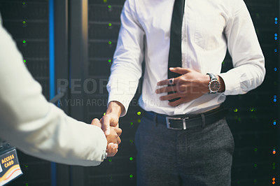 Buy stock photo Cropped shot of two unrecognizable IT specialists standing together in the server room and shaking hands