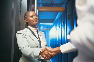 Buy stock photo Shot of a young IT specialist standing and shaking hands with a colleague in the server room