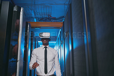 Buy stock photo Shot of a young IT specialist standing alone in the server room and wearing a virtual reality headset