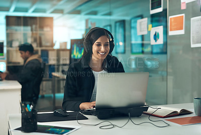 Buy stock photo Shot of a young woman using a headset and laptop in a modern office