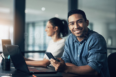 Buy stock photo Portrait of a young man using a cellphone in a modern office