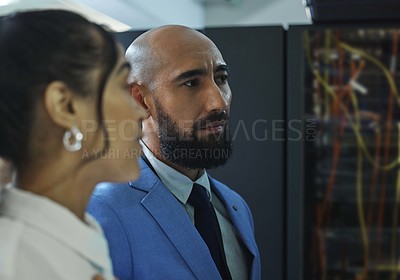 Buy stock photo Shot of two young workers doing maintenance checks in a server room at work