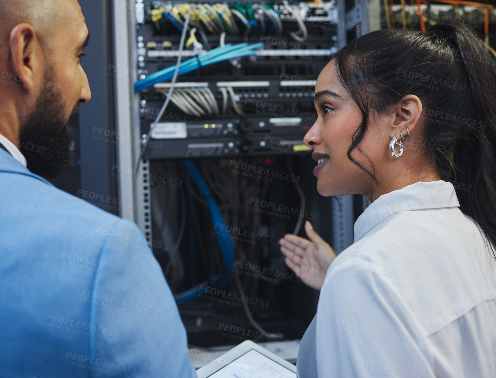 Buy stock photo Shot of two workers inspecting the electronic equipment in a server room together at work