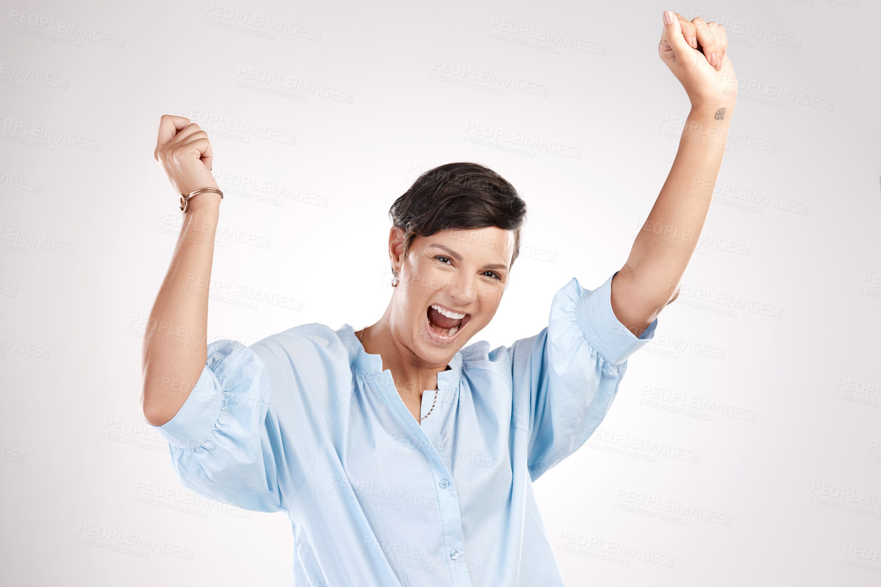 Buy stock photo Cropped portrait of an attractive young woman cheering in studio against a grey background