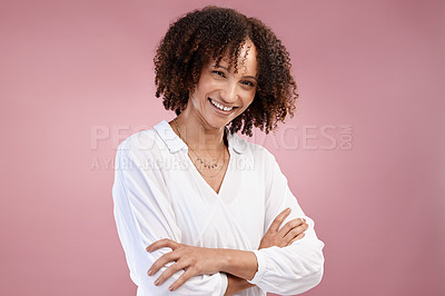 Buy stock photo Cropped portrait of an attractive young woman standing with her arms folded in studio against a pink background