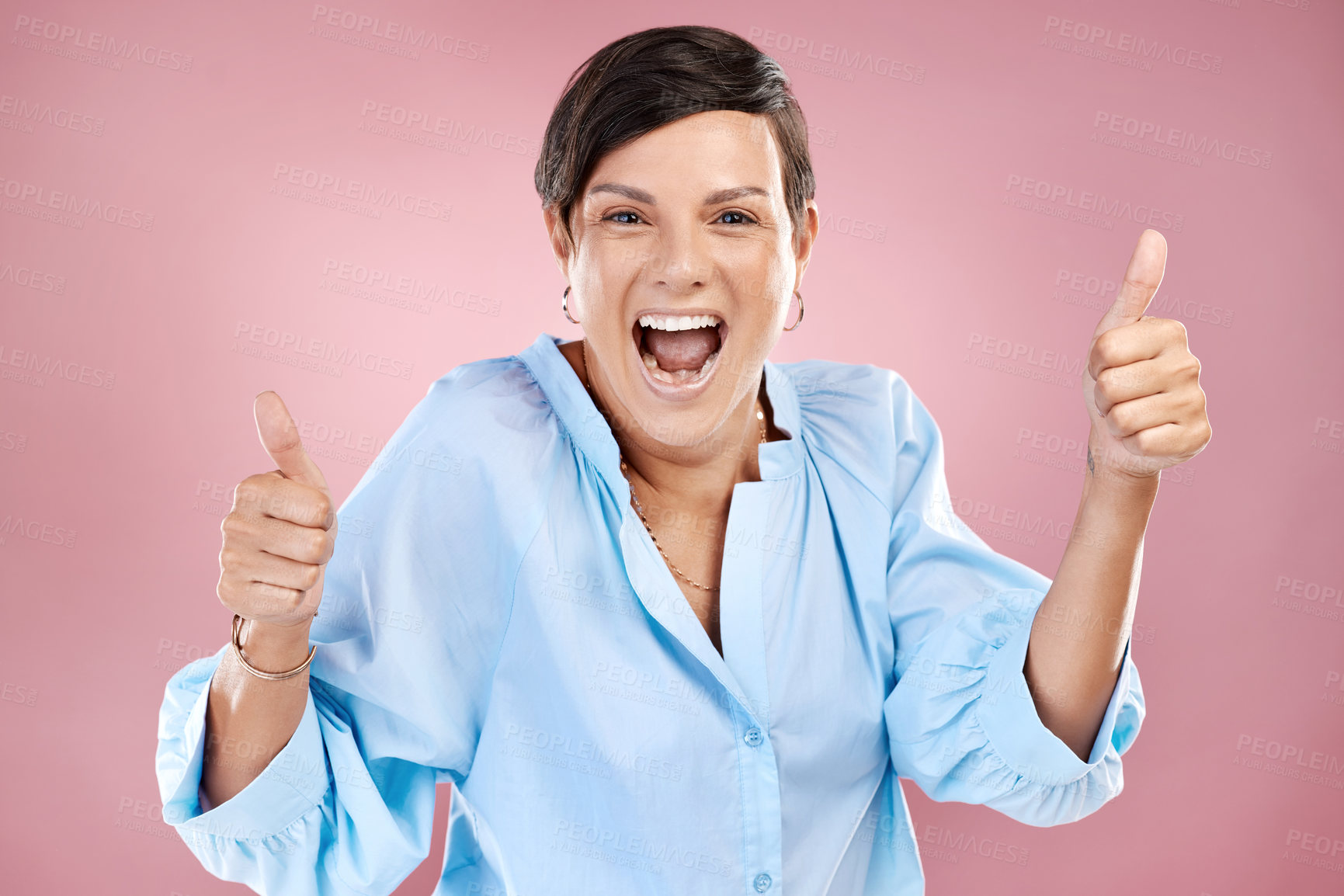 Buy stock photo Cropped portrait of an attractive young woman giving you two thumbs in studio against a pink background
