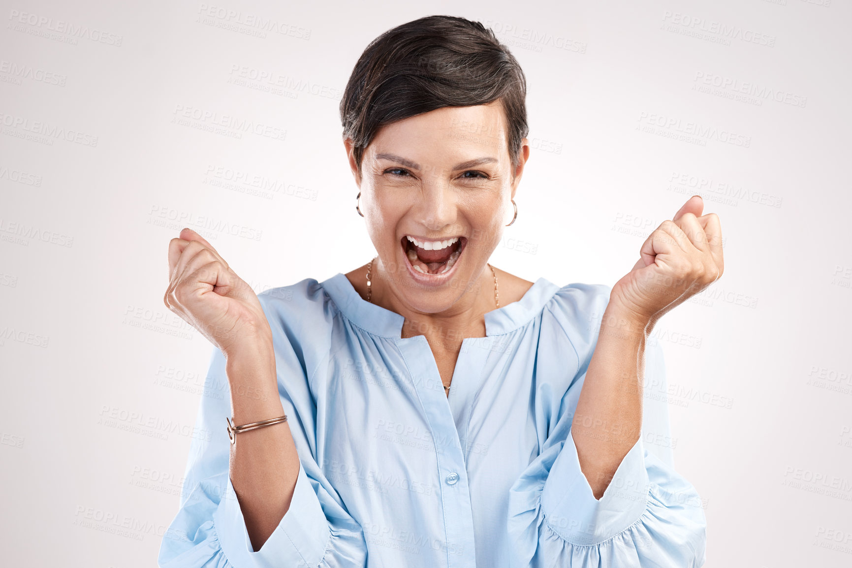 Buy stock photo Cropped portrait of an attractive young woman cheering in studio against a grey background