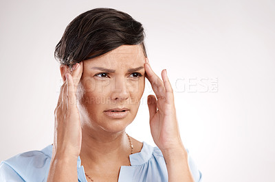 Buy stock photo Cropped shot of an attractive young woman suffering from a headache in studio against a grey background