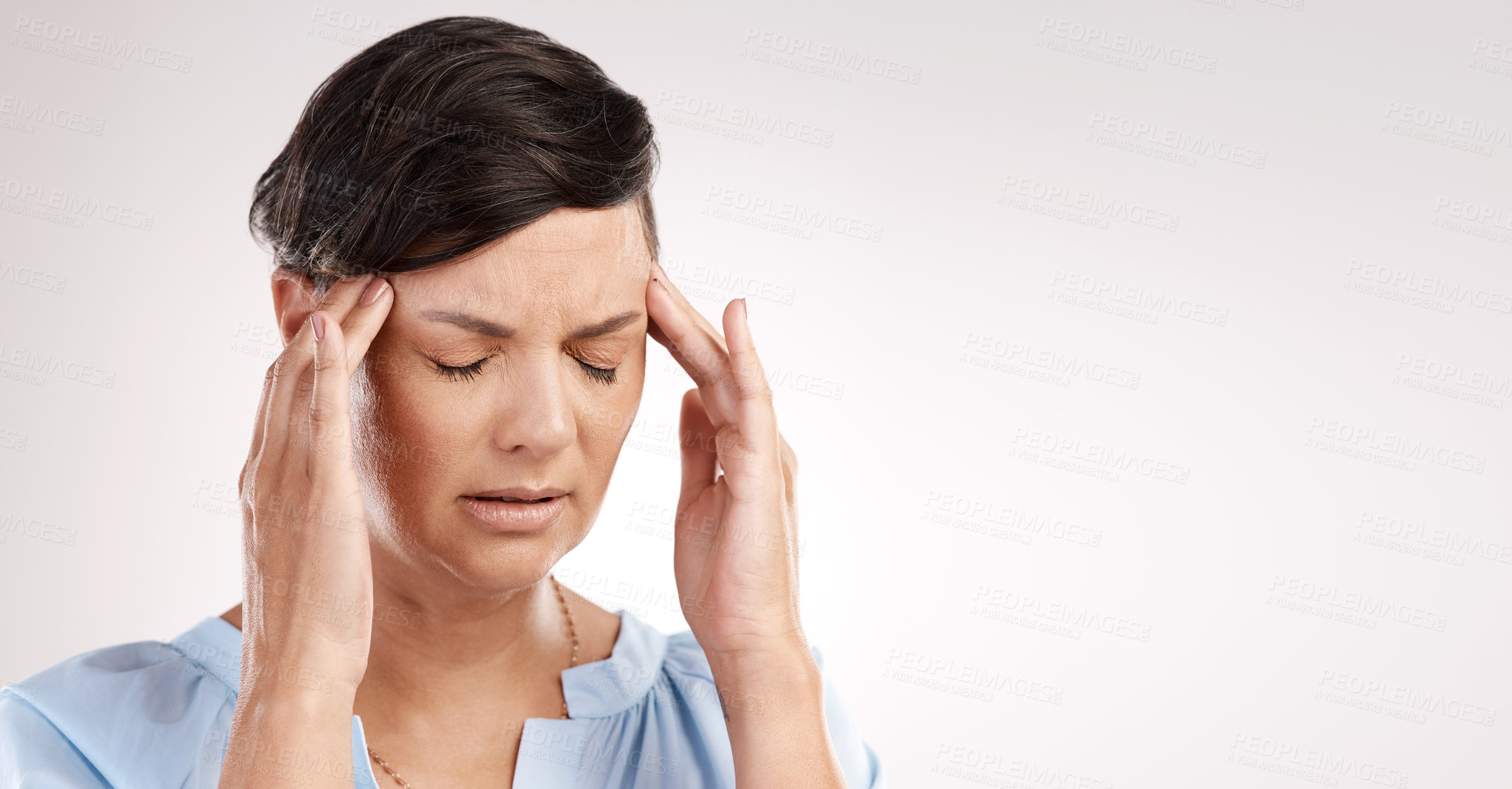Buy stock photo Cropped shot of an attractive young woman suffering from a headache in studio against a grey background