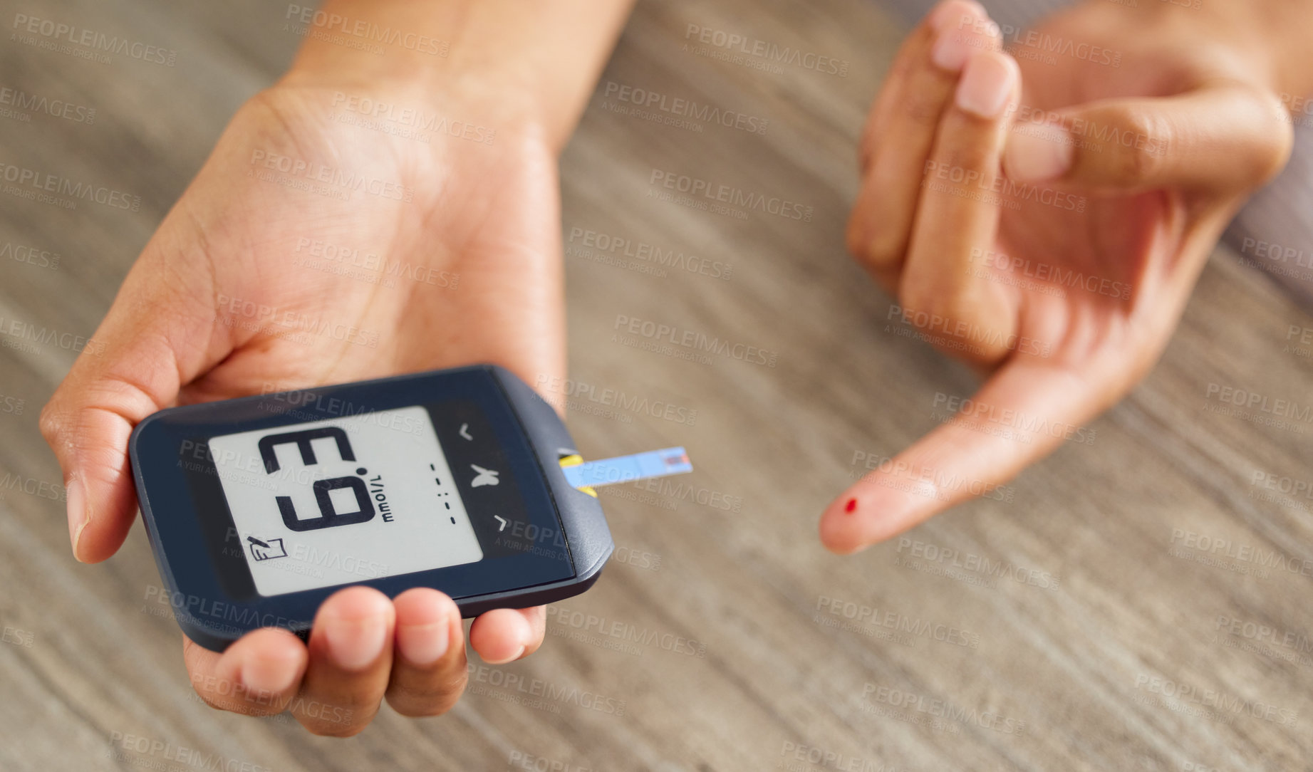 Buy stock photo High angle shot of an unrecognizable woman testing her blood sugar level at home