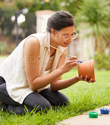 Buy stock photo Clay, pot and girl painting a craft container for plant in garden with creativity in hobby. Ceramic, art and artist outdoor with paint brush for fun decoration project for house and gardening