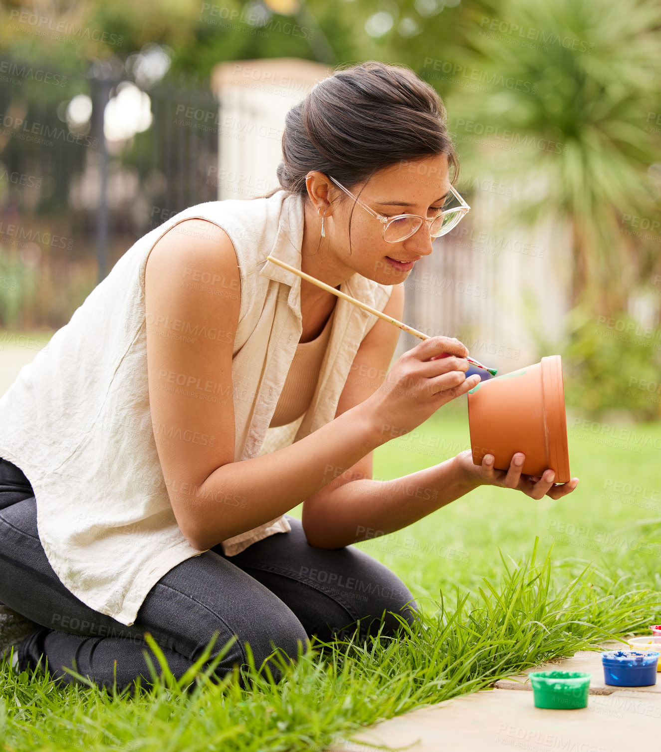 Buy stock photo Clay, pot and girl painting a craft container for plant in garden with creativity in hobby. Ceramic, art and artist outdoor with paint brush for fun decoration project for house and gardening