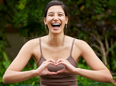 Buy stock photo Portrait of a young woman making a heart shape with her hands while exercising outdoors