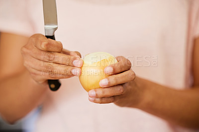 Buy stock photo Shot of a woman peeling an onion before cutting it