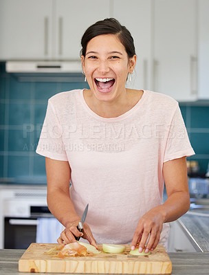 Buy stock photo Shot of a young woman cutting an onion