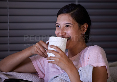 Buy stock photo Shot of a young woman drinking coffee while watching tv a home