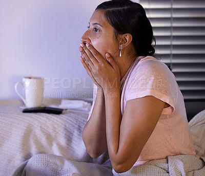 Buy stock photo Shot of a young woman looking shocked while watching tv at home