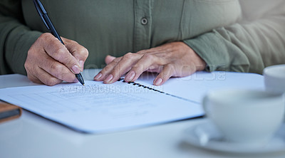 Buy stock photo Shot of an unrecognizable businessperson going through paperwork at work