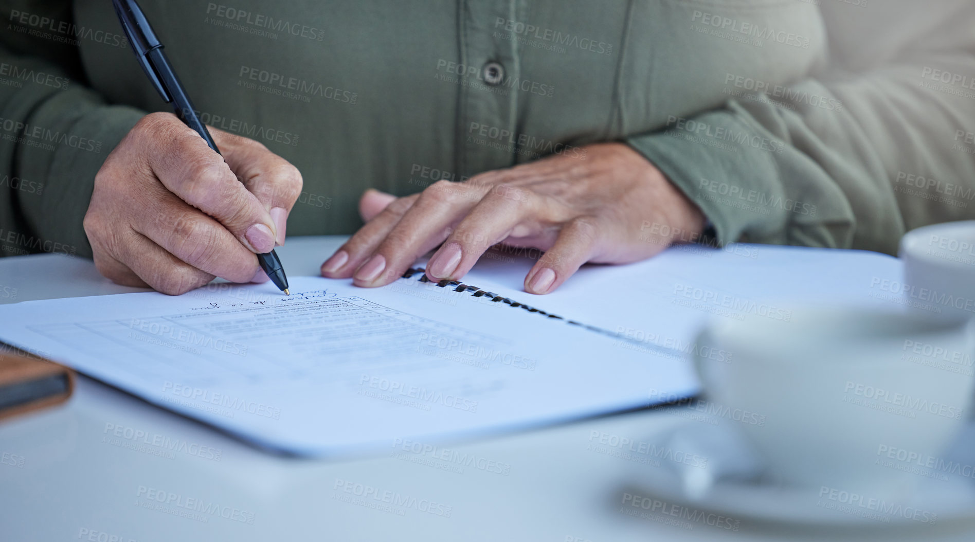 Buy stock photo Shot of an unrecognizable businessperson going through paperwork at work