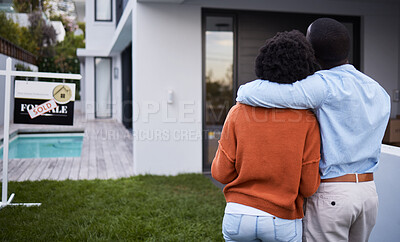 Buy stock photo Rearview shot of a young couple standing outside their new home