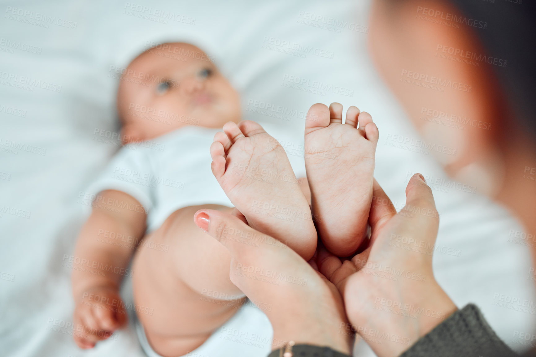 Buy stock photo Hands, baby and mother holding feet for growth, support and development in family home. Newborn, woman and wellness in bedroom for relax, security and together with love and care for child and mama 