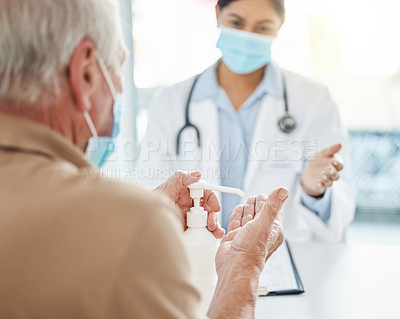 Buy stock photo Shot of an unrecognizable man sitting with his doctor and using hand sanitiser during his consult in the clinic