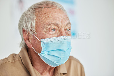 Buy stock photo Shot of a senior man sitting alone and wearing a face mask in the clinic during his consult