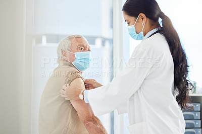 Buy stock photo Shot of a doctor wearing a face mask and preparing her senior patient for a Covid vaccine in her clinic