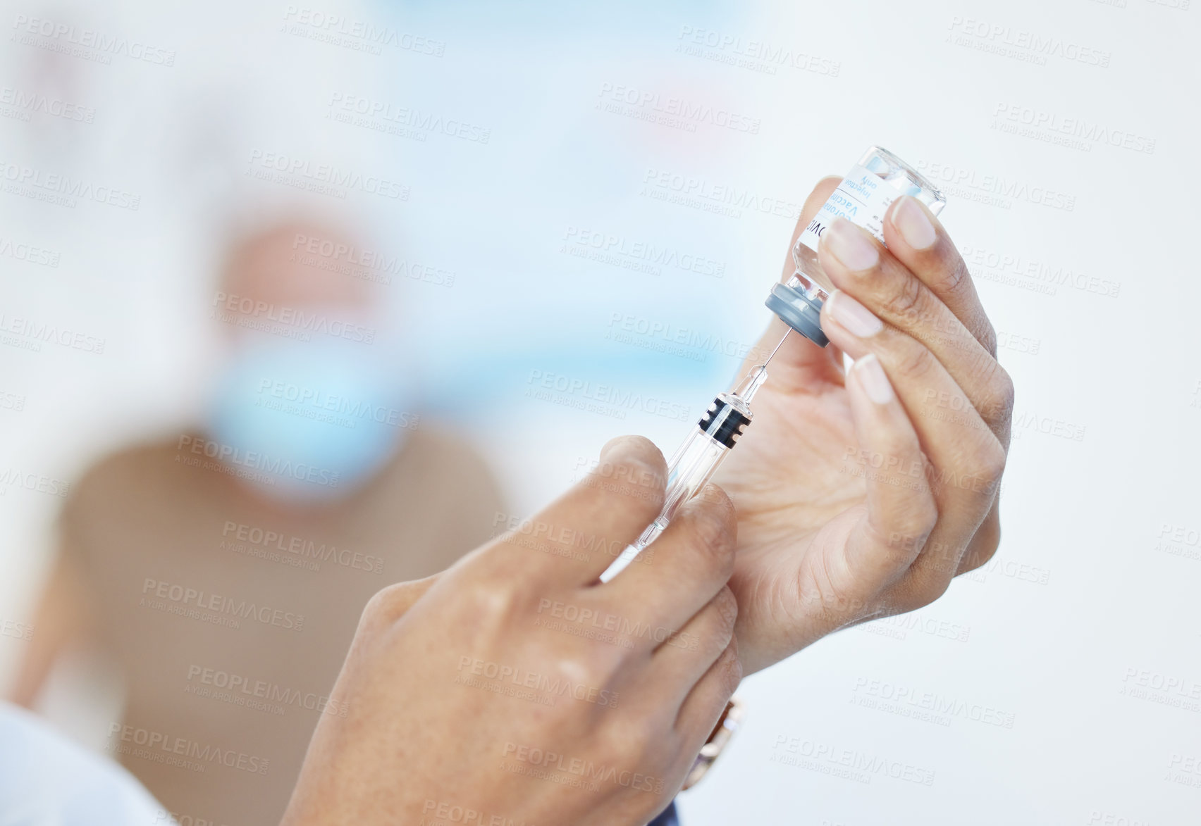 Buy stock photo Cropped shot of an unrecognizable doctor using a syringe to draw out the Covid vaccine in her clinic