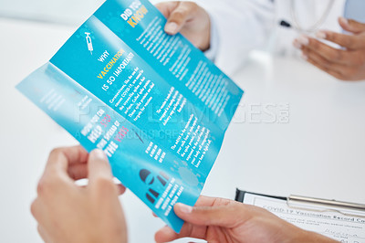 Buy stock photo Cropped shot of an unrecognizable doctor sitting with her patient and showing him a leaflet during a consult