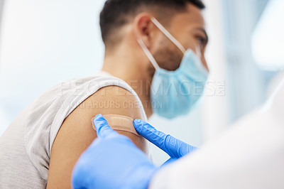 Buy stock photo Shot of an unrecognizable doctor putting a band-aid on her patient after giving him the Covid vaccine