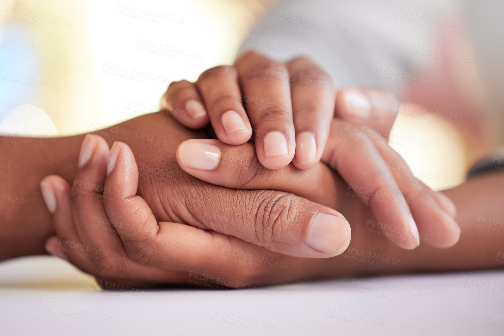 Buy stock photo Cropped shot of two unrecognizable people holding hands in comfort at a table at home