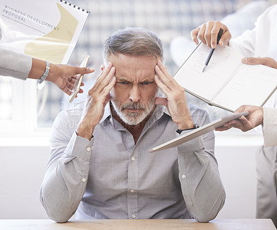 Buy stock photo Cropped shot of a handsome mature businessman looking stressed while being presented with multiple tasks at his desk in the office