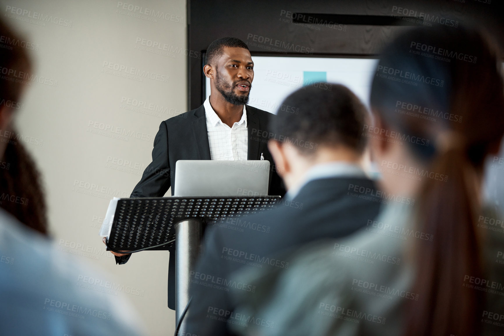 Buy stock photo Shot of a young businessman delivering a presentation during a conference